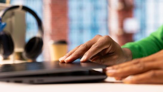 Man met groene trui opent laptop