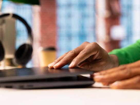 Man met groene trui opent laptop
